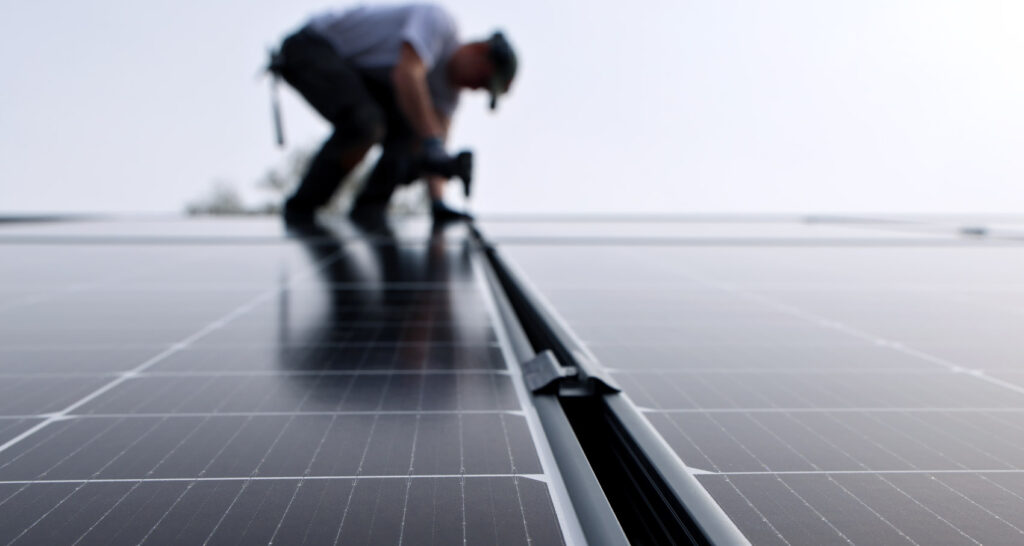 Techniker installiert Solaranlage auf einem Hausdach.