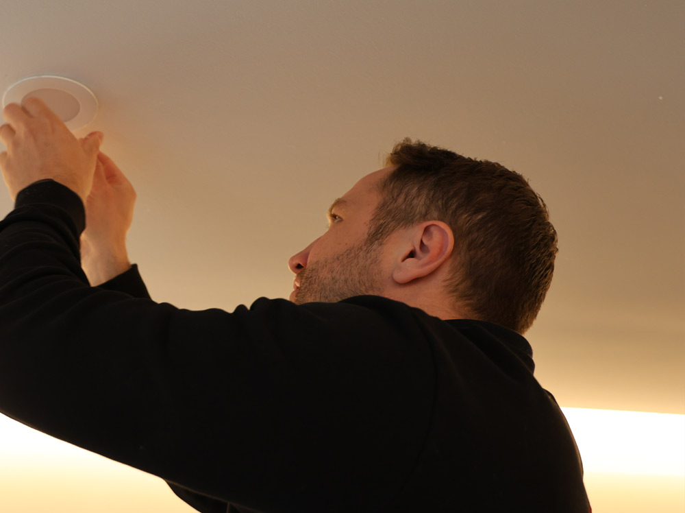 Techniker von der Firma LUK E-Technik aus Buchholz installiert Deckenlampe.